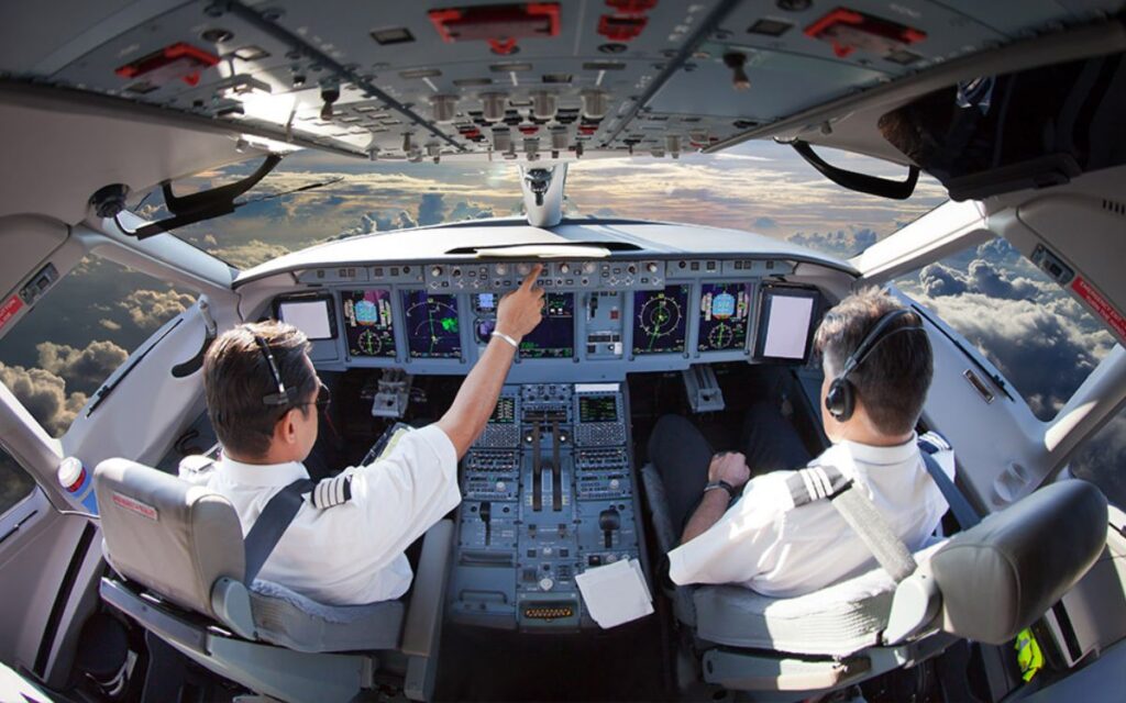 How much do pilots earn per month? 1 Two pilots sitting inside cockpit and operates airplane