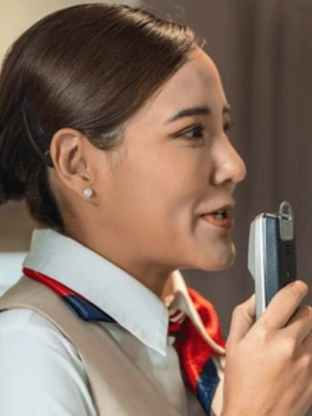 Air hostess in uniform speaking into an intercom microphone during flight operations